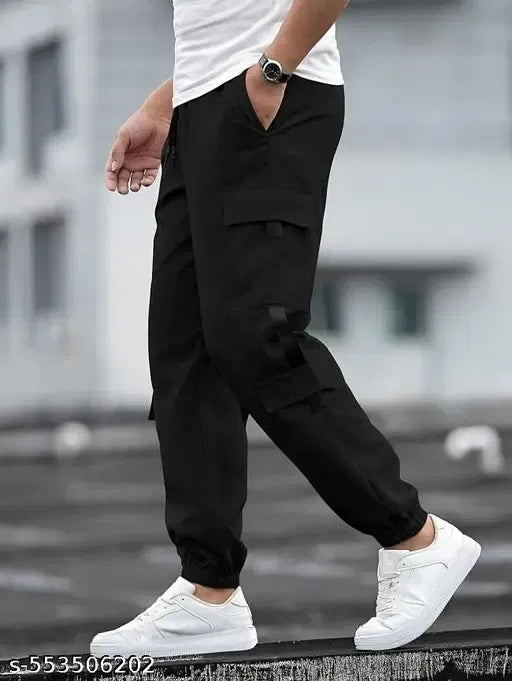 Person wearing black cargo pants and white sneakers on a blurred background